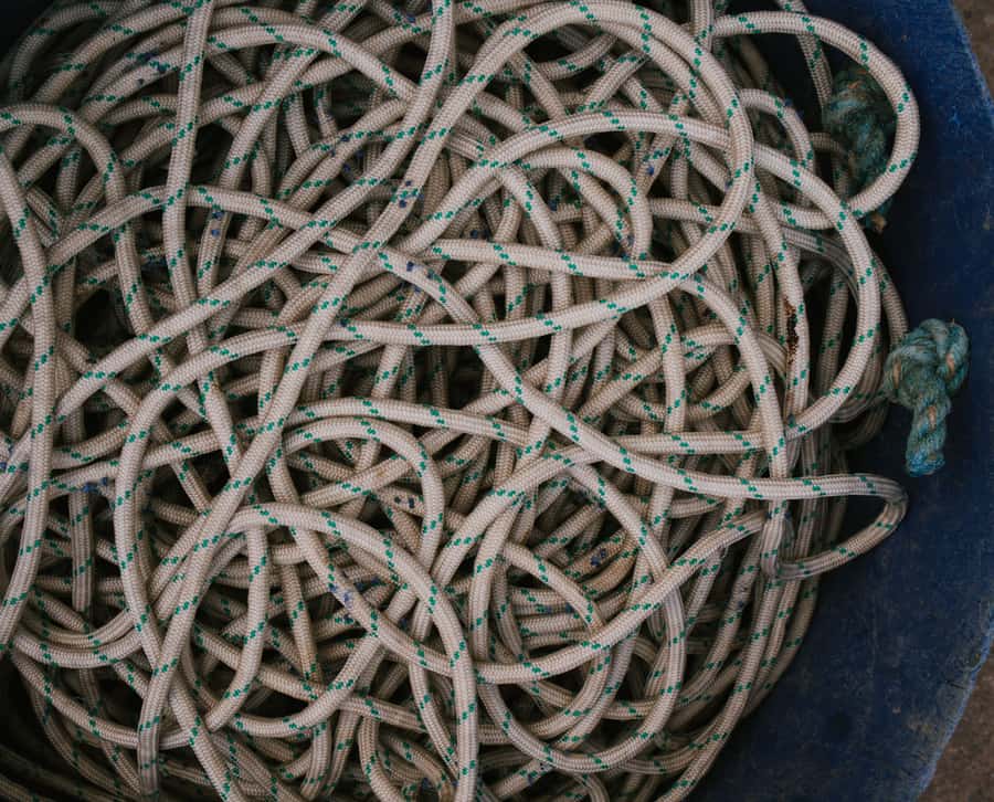 Tangled coil of braided cord piled in a dark bin